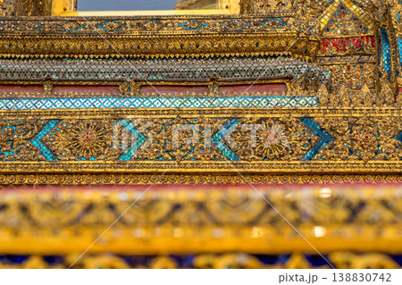 Tiny mirror pieces and gold surfaces show careful exterior work from the Rattanakosin era. The close framing reveals patient traditional craft. Tiny mirror pieces and gold surfaces show careful exterior work from the Rattanakosin era. The close framing reveals patient traditional craft. 138830742