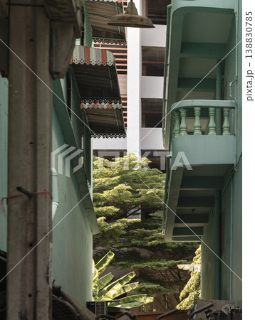 a narrow, upward-looking perspective of an alleyway between two buildings with a vintage, Southeast Asian architectural style. a narrow, upward-looking perspective of an alleyway between two buildings with a vintage, Southeast Asian architectural style. 138830785