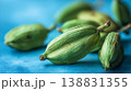 Close-up macro view of vibrant green cardamom pods on a textured blue surface 138831355