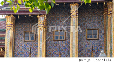 Patterned walls, frames, and roof edges create a rich study of Thai temple design. Repeated motifs and colors fill each close architectural view. 138831413