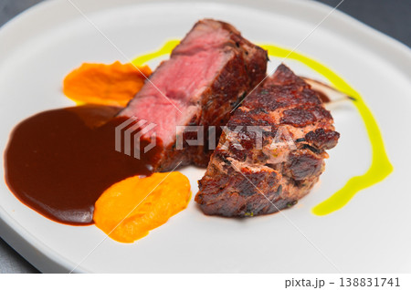 Grilled beef steak served with sauce and colorful vegetable puree on plate 138831741