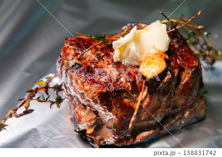 Grilled beef steak with herbs and butter on silver foil background Grilled beef steak with herbs and butter on silver foil background 138831742