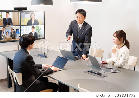 対面とオンラインを併用したビジネス会議で意見交換するシーン 対面とオンラインを併用したビジネス会議で意見交換するシーン 138831775
