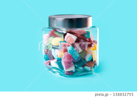 Colorful assorted gummy candies in glass jar on blue background Colorful assorted gummy candies in glass jar on blue background 138832755