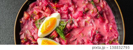 Delicious cold beet soup is garnished with boiled eggs and fresh herbs in a simple black bowl. The vibrant colors and textures create an inviting dish perfect for summer meals, banner Delicious cold beet soup is garnished with boiled eggs and fresh herbs in a simple black bowl. The vibrant colors and textures create an inviting dish perfect for summer meals, banner 138832793