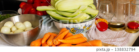 Fresh vegetables are arranged on a kitchen countertop for making squash caviar. Squash, carrots, tomatoes, and ingredients are prepared for winter canning, banner Fresh vegetables are arranged on a kitchen countertop for making squash caviar. Squash, carrots, tomatoes, and ingredients are prepared for winter canning, banner 138832794