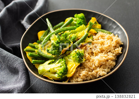 Quinoa bowl features boiled eggs, green beans, and broccoli. A fresh salad sits nearby. A cup of coffee completes the healthy breakfast setting Quinoa bowl features boiled eggs, green beans, and broccoli. A fresh salad sits nearby. A cup of coffee completes the healthy breakfast setting 138832821
