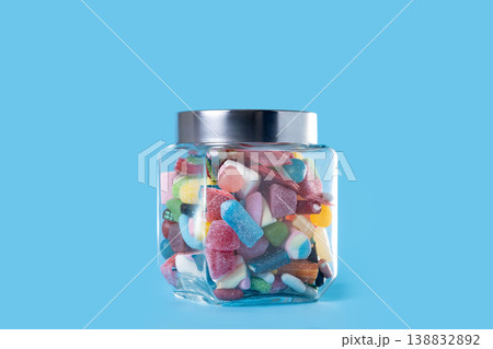 Colorful assorted gummy candies in glass jar on blue background Colorful assorted gummy candies in glass jar on blue background 138832892