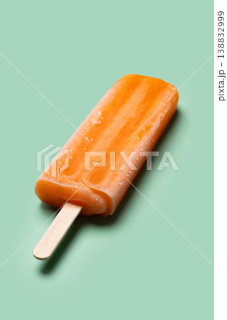 Orange popsicle on green background Orange popsicle on green background 138832999