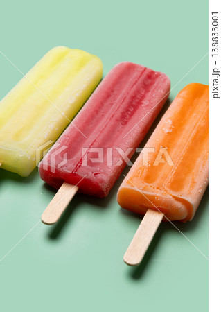 Colorful fruit popsicles on green background 138833001