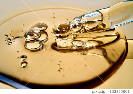 Yellow liquid oil drops in glass pipette 138833061
