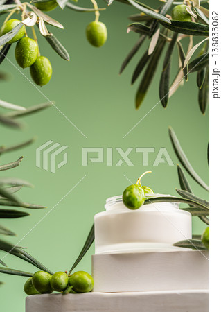 Olive branch with cream drop above cosmetic jar, natural skincare composition 138833082