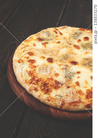 Freshly baked cheese pizza, with a golden crust and bubbling melted cheese, white pizza, on a wooden board, homemade, no people, 138833270