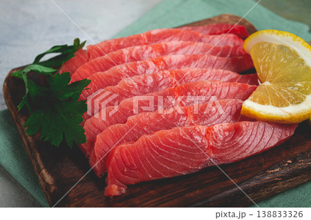 chum salmon, cold smoked, sliced, on a cutting board, with lemon and parsley, top view, close-up, no people, 138833326