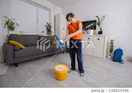 Child cleaning the living room with a mop and bucket Child cleaning the living room with a mop and bucket 138833598