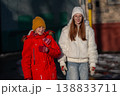 A boy and a teenage girl against the background of the street. They are in warm winter clothes. 138833711