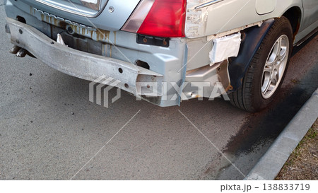 Car with damaged rear bumper parked near a sidewalk in an urban area during daylight Car with damaged rear bumper parked near a sidewalk in an urban area during daylight 138833719