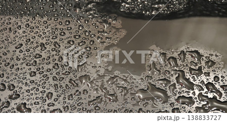 Water droplets gather on a metal surface creating various shapes and patterns during the afternoon Water droplets gather on a metal surface creating various shapes and patterns during the afternoon 138833727