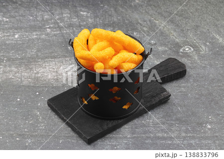 Cheese flavored corn puffs in wooden bowl on rustic wood background, crunchy savory cheese snacks 138833796