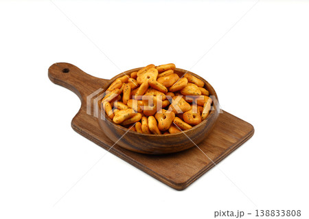 Crispy spicy triangle crackers in rustic wooden bowl isolated on white background, savory snack 138833808