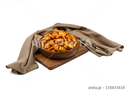 Crispy spicy triangle crackers in rustic wooden bowl isolated on white background, savory snack 138833810