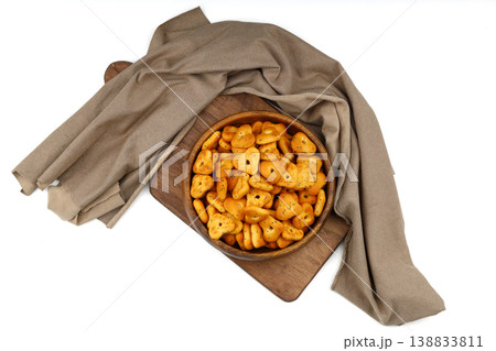 Crispy spicy triangle crackers in rustic wooden bowl isolated on white background, savory snack Crispy spicy triangle crackers in rustic wooden bowl isolated on white background, savory snack 138833811