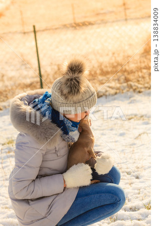Woman playing with dog during winter Woman playing with dog during winter 138834009