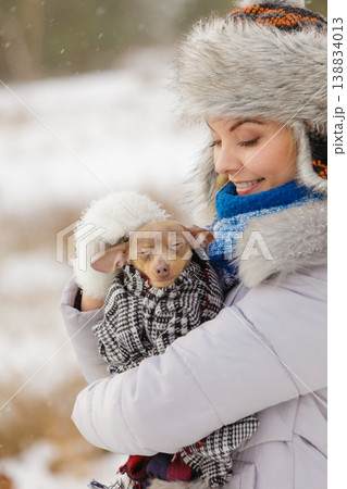 Woman hug warming her little dog in winter 138834013