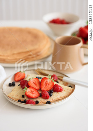 French homemade pancake crepes with strawberries on white table. French homemade pancake crepes with strawberries on white table. 138835118
