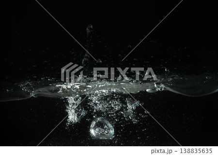 Water splashing, forming bubbles as it's poured into aquarium tank, black background Water splashing, forming bubbles as it's poured into aquarium tank, black background 138835635