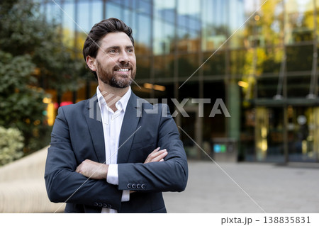 Confident businessman standing outdoors, looking away and smiling, portraying success, leadership, and a positive future with an urban office building background Confident businessman standing outdoors, looking away and smiling, portraying success, leadership, and a positive future with an urban office building background 138835831