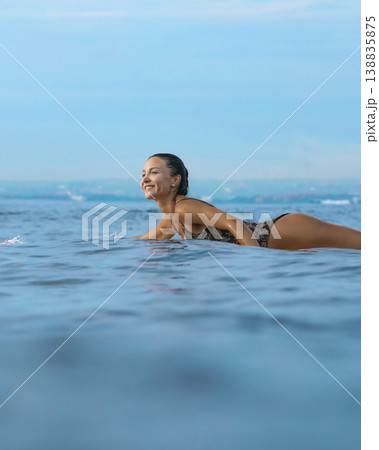 Young Woman Maintains Steady Stance During Evening Paddleboarding Session Young Woman Maintains Steady Stance During Evening Paddleboarding Session 138835875