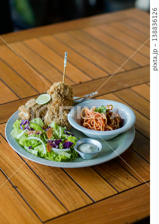 Western Style Fried Chicken with Pasta and Salad on Wooden Table 138836126