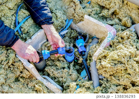 Distribution piping in artesian well pit well contractor using compression fittings to connect pipe sections. 138836293