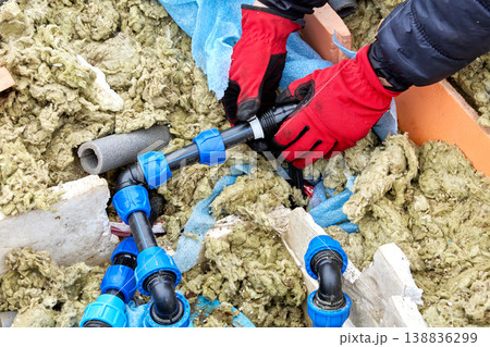 Plumber moving compression ring of compression fitting for HDPE pipes along pipe. Plumber moving compression ring of compression fitting for HDPE pipes along pipe. 138836299
