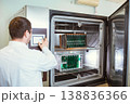 Engineer programs, sets up a test laboratory for finished printed circuit boards. Warm-cold test chamber with printed circuit boards installed during testing. 138836366