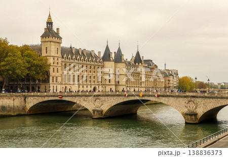 Conciergerie palace and Pont au Change bridge spanning the Seine River on a cloudy autumn day in Paris, France Conciergerie palace and Pont au Change bridge spanning the Seine River on a cloudy autumn day in Paris, France 138836373