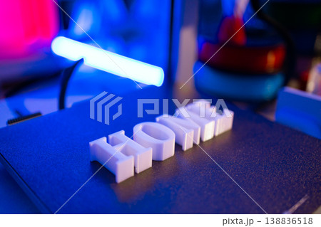 White 3D printed letters spelling out HOME sit on a dark textured surface illuminated by blue and pink neon lights White 3D printed letters spelling out HOME sit on a dark textured surface illuminated by blue and pink neon lights 138836518