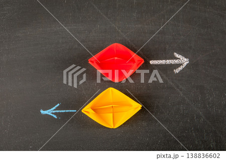 Opposite Direction Strategy Concept With Red and Yellow Paper Boats and Arrows 138836602