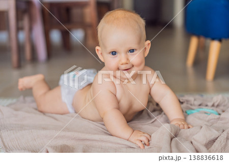 Baby lying on play mat learning to crawl and get on all fours. Infant practicing motor skills and development at home. Early childhood growth, milestones and active learning concept Baby lying on play mat learning to crawl and get on all fours. Infant practicing motor skills and development at home. Early childhood growth, milestones and active learning concept 138836618