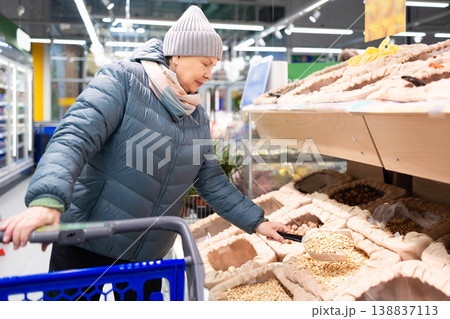 Senior woman shopping in modern supermarket during winter Senior woman shopping in modern supermarket during winter 138837113