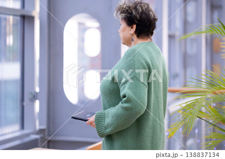 Mature woman working on laptop in shopping mall interior 138837134