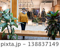 Mature woman walking in modern shopping mall near clothing store window 138837149