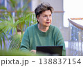 Mature woman working on laptop in shopping mall interior 138837154