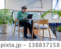 Mature woman working on laptop in shopping mall interior 138837158