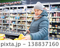 Senior woman shopping in modern supermarket during winter 138837160