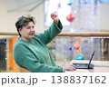 Mature woman working on laptop in shopping mall interior 138837162