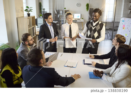 Mixed team of professionals in office meeting with presenting and project planning Mixed team of professionals in office meeting with presenting and project planning 138838190