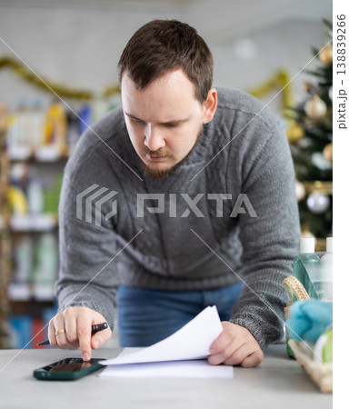 Male businessperson with paper document, plans to replenish restock stores inventory on Christmas Eve 138839266