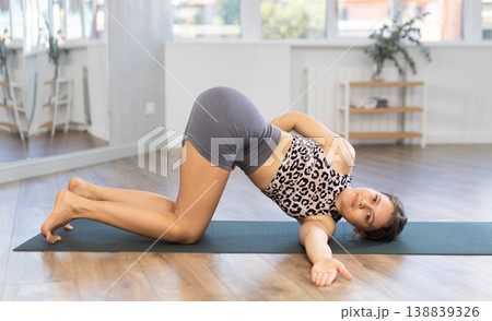 Young woman enjoying daily yoga practice in serene studio 138839326